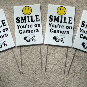 4 Smile You're On Camera Signs 8"x12" con Stakes Security Surveillance b/y ¡Envío gratis!