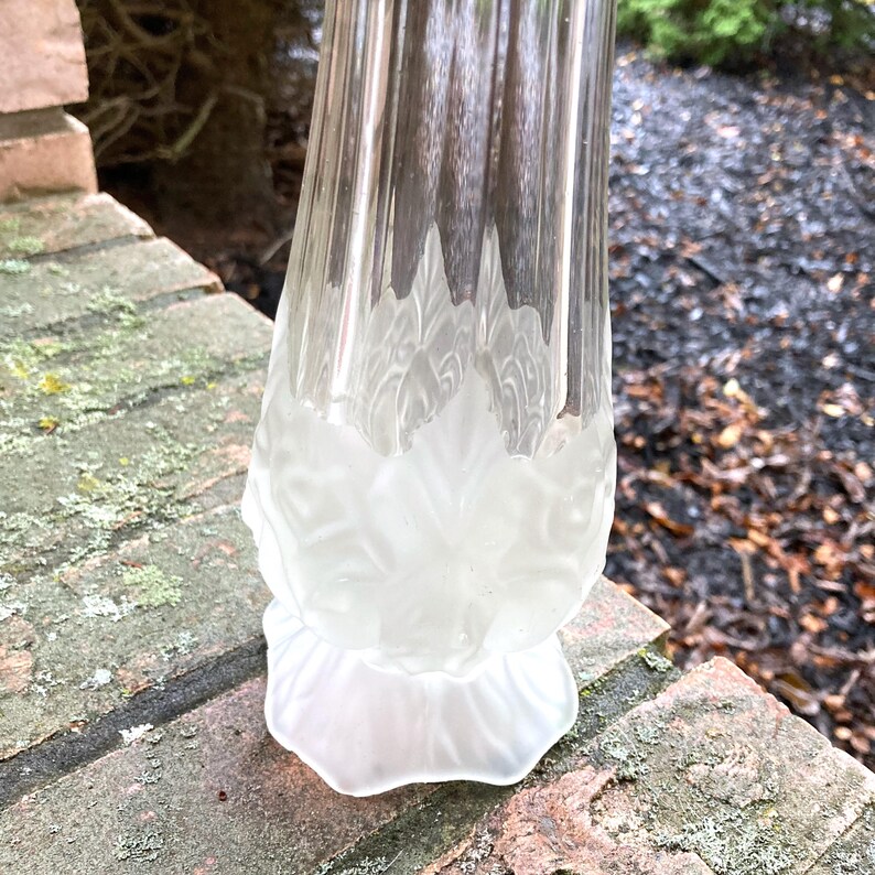 Op de afbeelding: Een gematteerde glazen vaas met een bloemenpatroon. De vaas is van helder glas met een gematteerde afwerking en een bloemenpatroon dat in het glas is ge&euml;tst.
