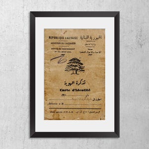 May include: A framed vintage Lebanese identity card featuring a cedar tree emblem, printed in both French and Arabic. The document includes the text REPUBLIQUE LIBANAISE, MINISTERE DE L'INTERIEUR, and Carte d'Identit&eacute;, set against a weathered tan paper background.
