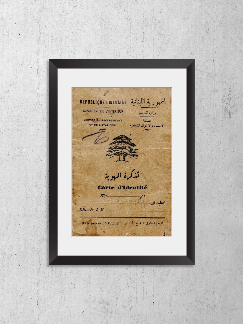 May include: A framed vintage Lebanese identity card featuring a cedar tree emblem, printed in both French and Arabic. The document includes the text REPUBLIQUE LIBANAISE, MINISTERE DE L'INTERIEUR, and Carte d'Identit&eacute;, set against a weathered tan paper background.