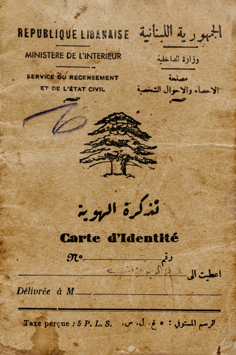 May include: A vintage Lebanese identity card printed on aged, tan paper. The document features the cedar tree emblem, text in French and Arabic including 'REPUBLIQUE LIBANAISE' and 'Carte d'Identit&eacute;', and a handwritten ink mark.