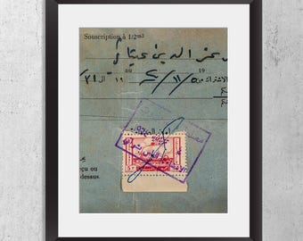 May include: A framed vintage document featuring blue paper with handwritten Arabic script, the text "Souscription à 1/2m3", and a red postage stamp with Arabic characters. A purple ink stamp overlaps the stamp and paper, set in a black frame.