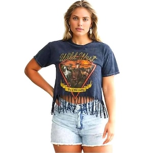 May include: A dark blue cropped t-shirt with a frayed hem. The shirt features a vintage-style graphic of a cowboy riding a horse with the text "Wild West" and "This is wild country".