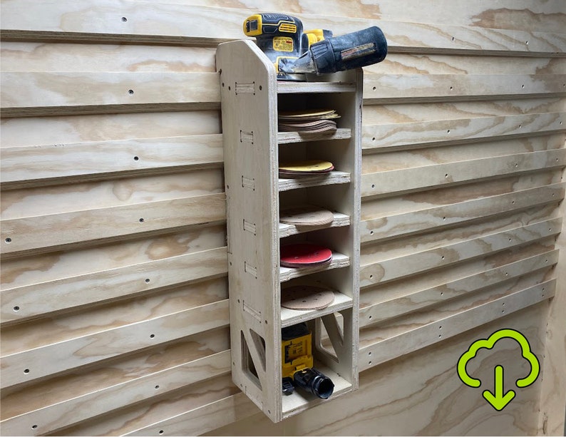 Op de afbeelding: Een houten wandgemonteerde opbergrek met zes planken voor het opbergen van schuurpapier. Een gele en zwarte elektrische schuurmachine bevindt zich op de bovenste plank.
