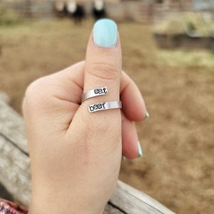 May include: A silver thumb ring with the words "eat beef" engraved on it.
