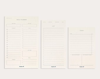 May include: Three off-white paper pads with minimalist designs. The pads include a daily planner, a to-do list, and a daily schedule. Each pad has the words "simple self" printed at the bottom.