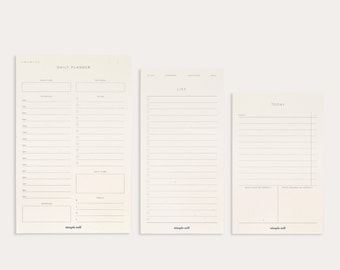 May include: Three cream-colored paper pads with minimalist designs. The pads include a daily planner, a to-do list, and a daily schedule. Each pad has the words "simple self" printed at the bottom.