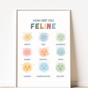 Può includere: Una stampa incorniciata con il testo "How Are You Feline" sopra illustrazioni di facce di gatto che esprimono diverse emozioni. Le emozioni includono felice, triste, preoccupato, arrabbiato, giocoso, calmo, spaventato, deluso ed eccitato. L'opera d'arte è in colori pastello.