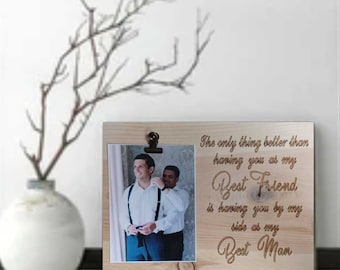 May include: A wooden picture frame with a photo of two men in a suit. The frame has a clip at the top and the text "The only thing better than having you as my Best Friend is having you by my side as my Best Man".