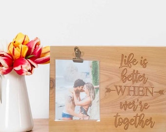 May include: A wooden photo frame with a clip to hold a photo. The frame has the text "Life is better when we're together" engraved on it.
