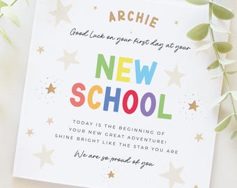 May include: A square greeting card with the name "ARCHIE" in brown letters. The card says "Good Luck on your first day at your NEW SCHOOL" in colorful letters. The card is decorated with stars and the text "We are so proud of you."