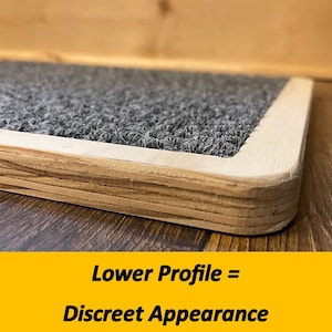 May include: Close-up of a rectangular, low-profile platform with a gray, textured surface and a light wood frame. The text "Lower Profile = Discreet Appearance" is displayed on a yellow background.