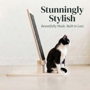 May include: A light-colored wooden cat scratching post with a dark gray textured surface, featuring the text "Stunningly Stylish" and "Beautifully Made. Built to Last." A black and white cat sits next to the vertical scratching board.