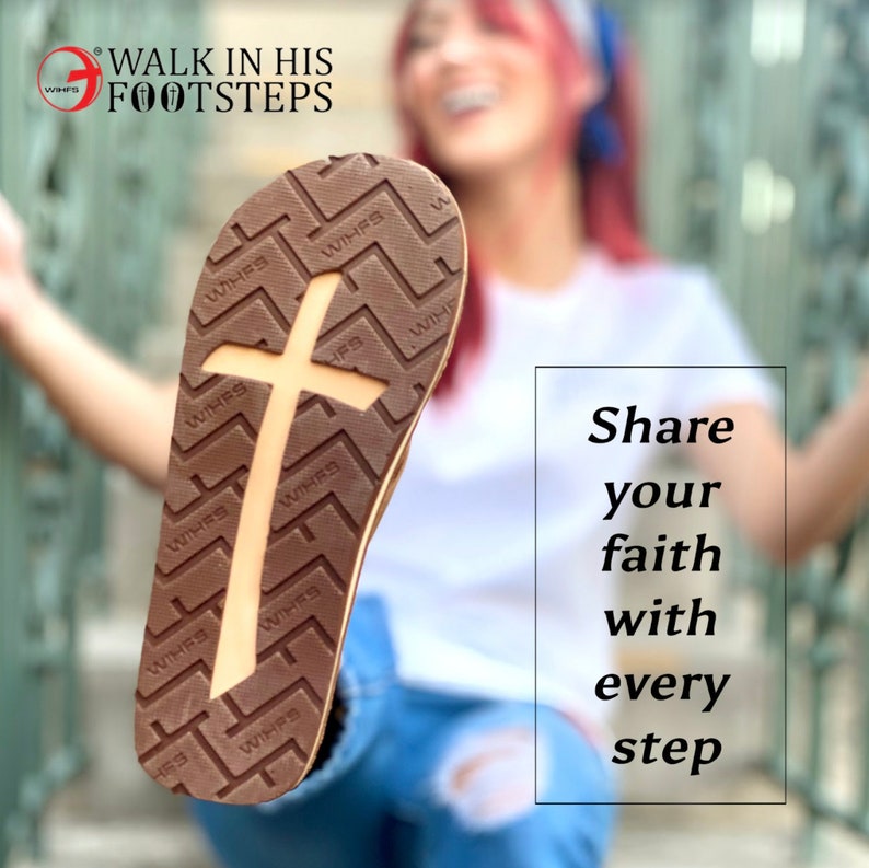 Op de afbeelding: Een bruine sandaal met een wit kruisontwerp op de zool. De zool heeft de woorden "WIHFS" meerdere keren herhaald. De tekst "WALK IN HIS FOOTSTEPS" is zichtbaar op de achtergrond. De tekst "Share your faith with every step" is ook zichtbaar op de achtergrond.