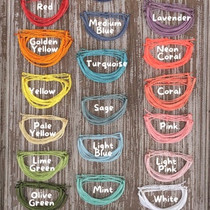 Puede incluir: Una colección de 20 pulseras de cuerda de diferentes colores, dispuestas en tres columnas. Los colores incluyen marrón, azul marino, morado, rojo, lavanda, azul medio, amarillo dorado, coral neón, turquesa, amarillo, coral, salvia, amarillo pálido, rosa, azul claro, verde lima, rosa claro, menta, verde oliva, blanco, negro, verde cazador y gris.