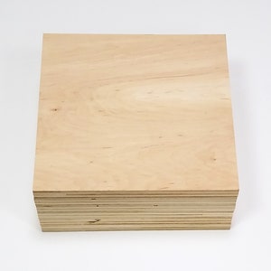May include: A stack of unfinished plywood boards. The wood has a light, natural color with visible grain patterns. The edges of the boards show the layered construction. The stack is square and sits on a white background.