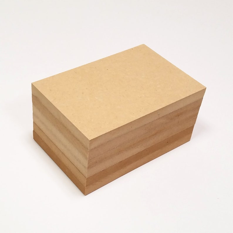 Puede incluir: Una pila de hojas de papel kraft marr&oacute;n. Las hojas son rectangulares y tienen una textura rugosa.