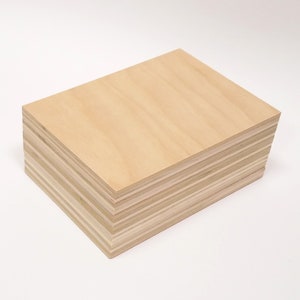May include: A stack of light brown plywood sheets. The sheets are stacked neatly and show the layers of wood.