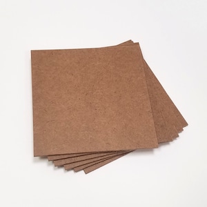 May include: A stack of six brown craft paper squares.