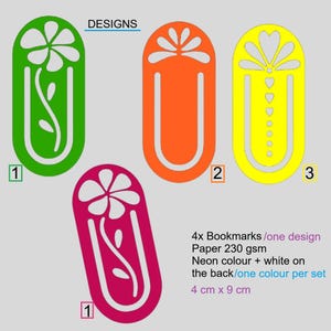 May include: Four colorful bookmarks with unique designs. The bookmarks are in green, orange, yellow, and magenta. Each bookmark is approximately 1.5 inches wide and 3.5 inches long. The text "DESIGNS" is at the top.