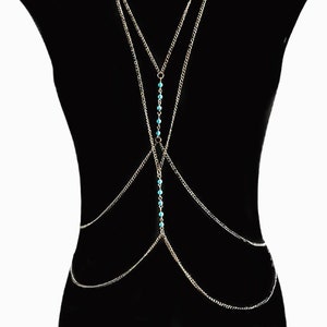 Könnte beinhalten: Eine goldene Körperkette mit mehreren Lagen und türkisfarbenen Perlen. Die Kette ist so konzipiert, dass sie um den Oberkörper getragen werden kann.