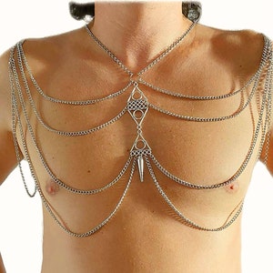 May include: Silver chain body jewelry with a geometric pendant. The chain is layered and has a pointed tip at the bottom.