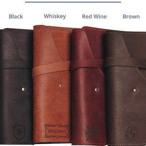 May include: Four leather-bound journals in different colors: black, brown, red wine, and whiskey. Each journal has a different engraved design on the front cover.