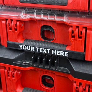 May include: A stack of red and black toolboxes with clear lids and black latches. Each toolbox has a handle and the text "YOUR TEXT HERE" on a black label. The toolboxes are stacked on top of each other.