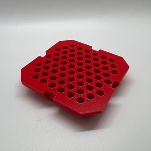 May include: Red plastic tray with a honeycomb pattern. The tray has a square shape and is made of a durable material.