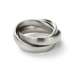 Könnte beinhalten: Ein silberner, ineinandergreifender Ring mit gebürsteter Oberfläche. Der Ring besteht aus drei ineinander verschlungenen Bändern.