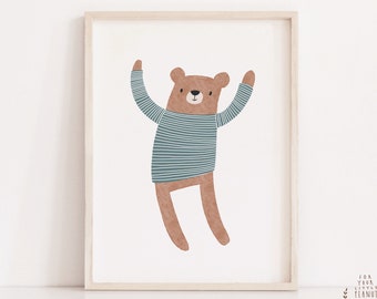 May include: A brown bear wearing a blue and white striped shirt with its arms raised in the air. The bear is against a white background inside a light wood frame.