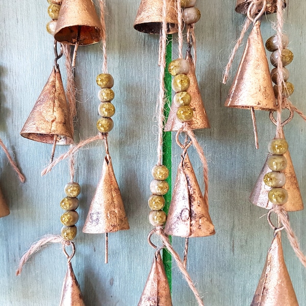 Windchime avec des cloches de vache en métal de couleur or vintage et des perles de crack en céramique faites à la main de couleur vert olive, des cloches sur une ficelle, un mur suspendu