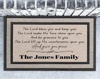 May include: A brown doormat with a beige background and black border. The doormat has a religious quote and the text "The Jones Family" in black.