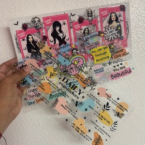 May include: A collection of colorful stickers with positive affirmations and inspirational quotes. The stickers feature a variety of designs, including butterflies, stars, and flowers. The text on the stickers includes phrases like "You are beautiful", "Take a deep breath", and "Keep your head up".
