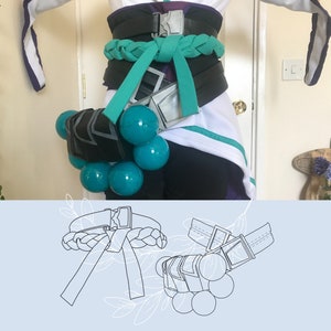 May include: A black and green belt with a braided design and a silver buckle. The belt is decorated with a series of teal-coloured spheres.