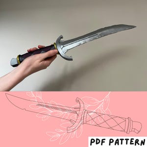 Puede incluir: Una espada de utilería con hoja plateada, mango oscuro con textura de rombos y detalles dorados en la guarda y el pomo. Debajo, un dibujo lineal de la espada se muestra sobre un fondo rosa con el texto PDF PATTERN.