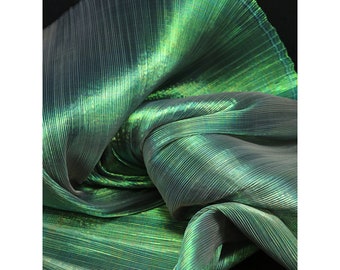 Peut inclure: Tissu vert iridescent à texture plissée. Le tissu est plié et drapé, montrant l'effet chatoyant du matériau.
