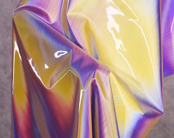 May include: A close-up of iridescent fabric with a yellow, purple, and pink color gradient. The fabric has a shiny, glossy finish.