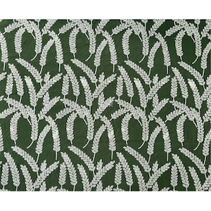 May include: A green fabric with a white floral pattern. The pattern is a repeating design of small white sprigs.