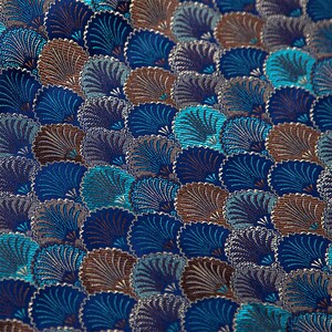 May include: A close-up of a fabric with a repeating pattern of blue, teal, and brown stylized fan shapes.
