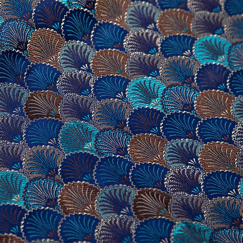 May include: A close-up of a fabric with a repeating pattern of blue, teal, and brown stylized fan shapes.