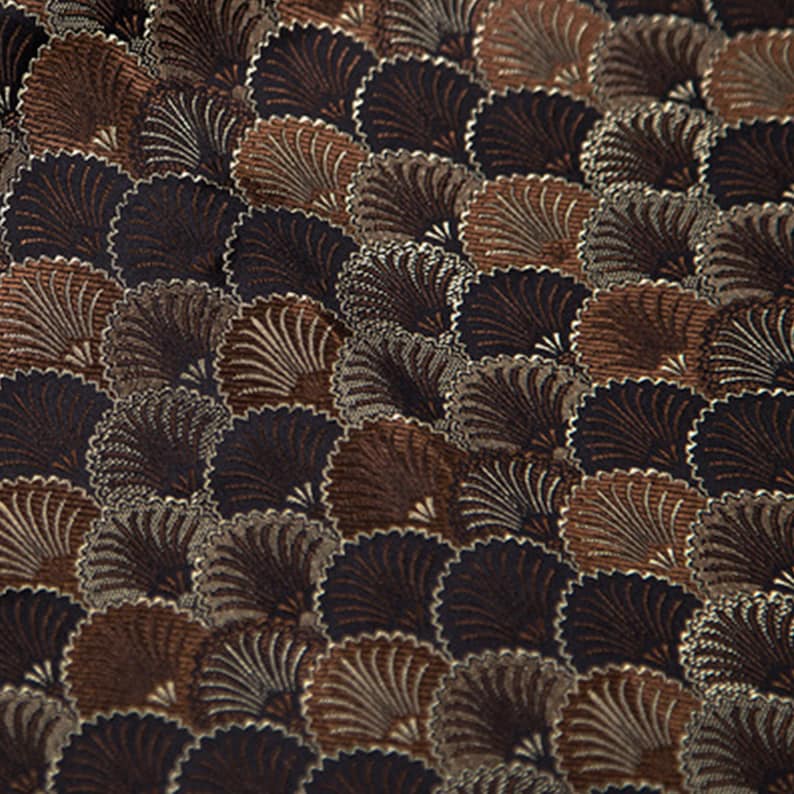 May include: A brown and black fabric with a repeating pattern of stylized fans. The fabric has a textured, woven look.