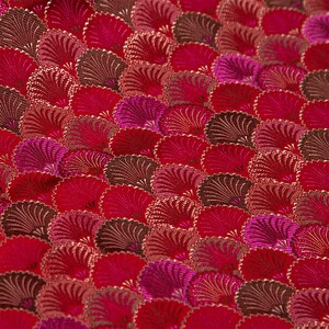 May include: Red fabric with a repeating pattern of pink and brown stylized fans.