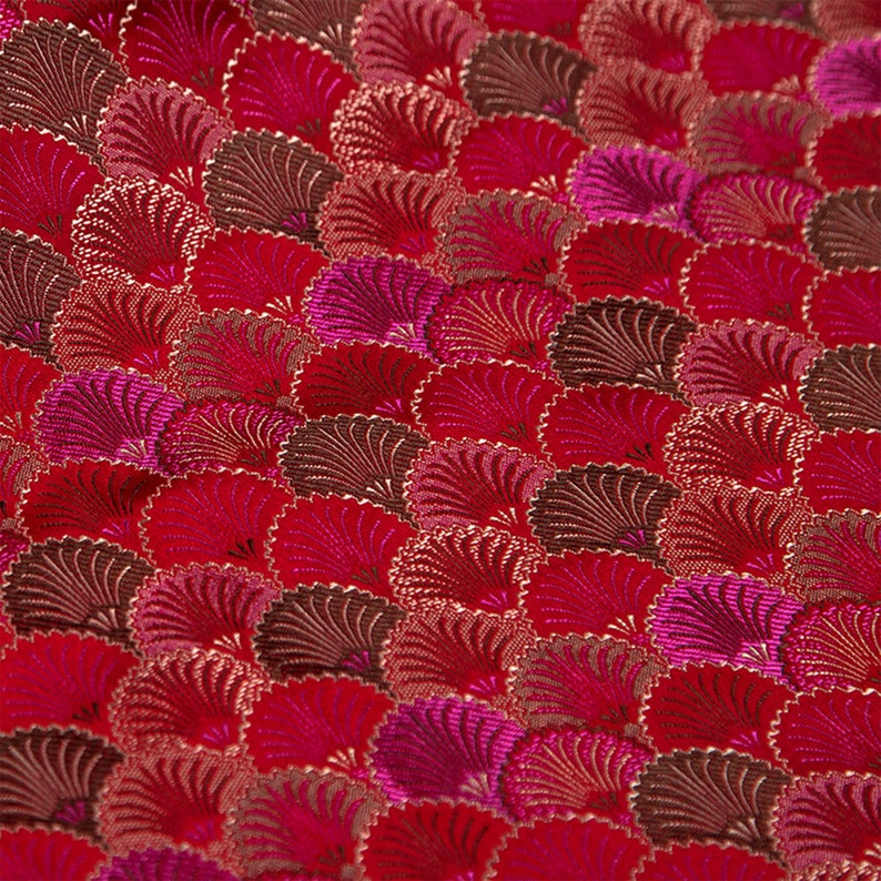 May include: Red fabric with a repeating pattern of pink and brown stylized fans.