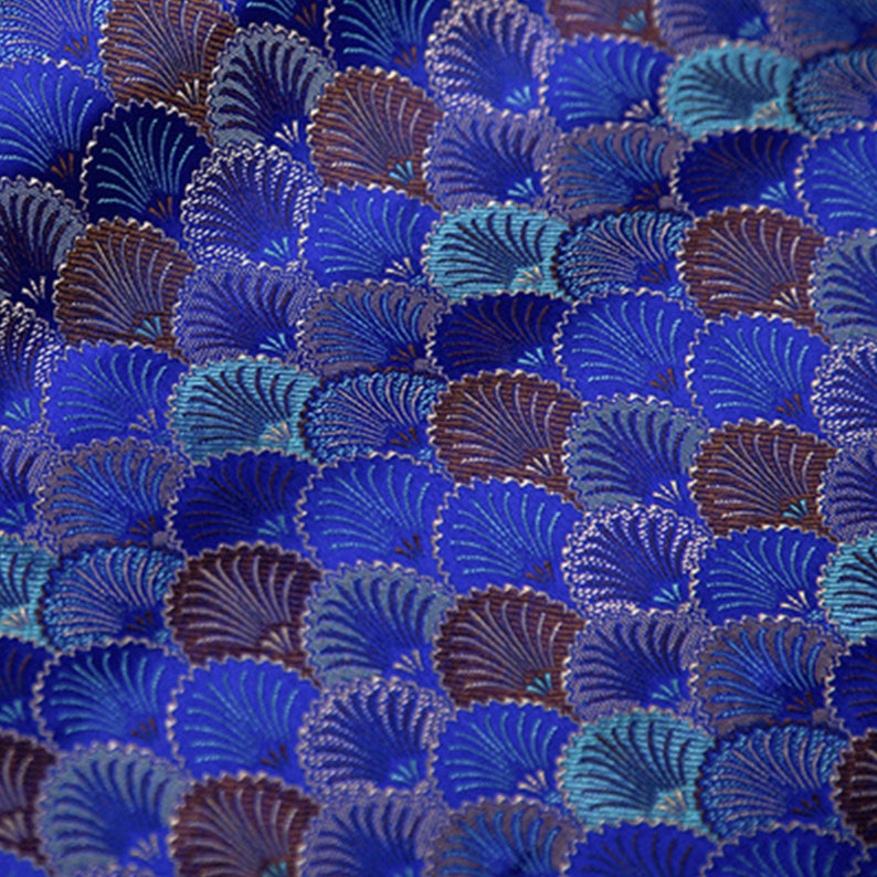 May include: Blue fabric with a repeating pattern of stylized fans in shades of blue, purple, and brown.
