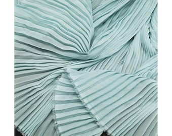May include: A light blue pleated fabric with a soft, flowing texture. The fabric is folded and draped, showcasing the delicate pleats.