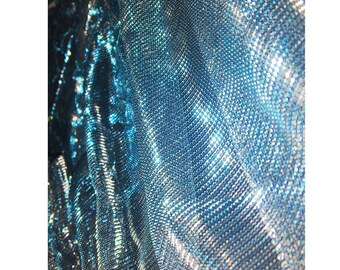 May include: Close-up of a shimmering blue and silver fabric with a textured, chainmail-like pattern.