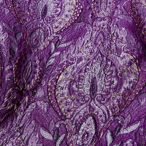 May include: Purple fabric with a silver and gold paisley pattern.