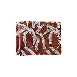 May include: A brown fabric with a white floral pattern. The fabric has a subtle texture and a slightly distressed look.