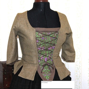 May include: A brown wool bodice with a lace-up front and floral embroidery. The bodice is made of 100% wool and has a terracotta-olive color.